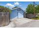 Light blue garage with double doors, complimented by lush greenery and a partial view of the sky at 2710 8Th N Ave, St Petersburg, FL 33713