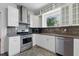 Updated kitchen with stainless appliances, white cabinets, and a mosaic backsplash at 2710 8Th N Ave, St Petersburg, FL 33713