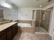Bathroom featuring double sink vanity, bathtub, and glass shower at 2731 Hampton Green Ln, Brandon, FL 33511