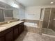 Bathroom featuring double sink vanity, bathtub, and glass shower at 2731 Hampton Green Ln, Brandon, FL 33511