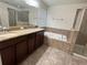 Bathroom featuring double sink vanity, bathtub, and glass shower at 2731 Hampton Green Ln, Brandon, FL 33511