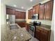 Spacious kitchen featuring stainless steel appliances, granite countertops and dark wood cabinets at 2731 Hampton Green Ln, Brandon, FL 33511