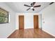 Bright bedroom features wood floors, a ceiling fan, a window, and two wood panel doors at 280 Fortaleza St, Punta Gorda, FL 33983