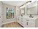 Bright bathroom features a double sink vanity with modern fixtures and a window with a view at 28516 Tranquil Lake Cir, Wesley Chapel, FL 33543