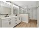 Modern bathroom featuring double vanity, hardwood floors, and glass shower at 28516 Tranquil Lake Cir, Wesley Chapel, FL 33543