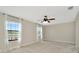 Bright bedroom with plush carpet, neutral walls, and modern ceiling fan and two large windows at 28516 Tranquil Lake Cir, Wesley Chapel, FL 33543
