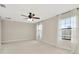 Bright bedroom with plush carpet, neutral walls, and modern ceiling fan and large windows at 28516 Tranquil Lake Cir, Wesley Chapel, FL 33543