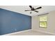 Bright bedroom with blue wall features plush carpet, a window, and a modern ceiling fan at 28516 Tranquil Lake Cir, Wesley Chapel, FL 33543