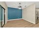 Dining area features stylish light fixture, accent wall, and sliding glass doors at 28516 Tranquil Lake Cir, Wesley Chapel, FL 33543