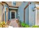 Inviting front entrance with a black front door, tiled walkway, and blue siding at 28516 Tranquil Lake Cir, Wesley Chapel, FL 33543
