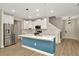 Modern kitchen featuring a large island with blue accents, stainless steel appliances, and stylish pendant lighting at 28516 Tranquil Lake Cir, Wesley Chapel, FL 33543