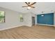 Bright, airy living room with wood-look floors, ceiling fan, and a modern lighting fixture at 28516 Tranquil Lake Cir, Wesley Chapel, FL 33543