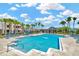 Resort-style swimming pool featuring sun loungers, palm trees, and a pool house at 28516 Tranquil Lake Cir, Wesley Chapel, FL 33543