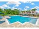 Resort-style community pool surrounded by lounge chairs, lush landscaping and buildings at 28516 Tranquil Lake Cir, Wesley Chapel, FL 33543