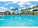 Large swimming pool with blue lounge chairs, palm trees, and a modern pool house at 28516 Tranquil Lake Cir, Wesley Chapel, FL 33543