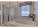 Bright bathroom showcasing a garden tub, glass-enclosed shower, and neutral tile at 29 Seagrape Cir, Clearwater, FL 33759
