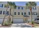 Townhome exterior with a two-car garage, tropical landscaping and covered entry at 29 Seagrape Cir, Clearwater, FL 33759