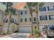 Townhouse exterior with palm trees, attached garages, and well manicured landscaping at 29 Seagrape Cir, Clearwater, FL 33759