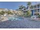 Community pool with lounge chairs surrounded by mature landscaping at 29 Seagrape Cir, Clearwater, FL 33759