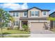 Charming two-story home with well-manicured lawn and an attached two-car garage at 3113 Marine Grass Dr, Wimauma, FL 33598