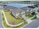 An attractive two-story home with a well-kept lawn, paver driveway, and picturesque lake view nearby at 3113 Marine Grass Dr, Wimauma, FL 33598