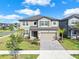 Two-story home featuring a two-car garage and well-manicured landscaping at 3113 Marine Grass Dr, Wimauma, FL 33598