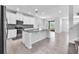 Modern kitchen with white cabinets, granite countertops, stainless steel appliances, and center island, perfect for cooking at 3113 Marine Grass Dr, Wimauma, FL 33598