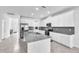 Open-concept kitchen featuring white cabinets, granite countertops, stainless steel appliances, and spacious island for cooking at 3113 Marine Grass Dr, Wimauma, FL 33598