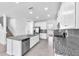Spacious kitchen featuring white cabinets, granite countertops, stainless steel appliances, and central island with dishwasher at 3113 Marine Grass Dr, Wimauma, FL 33598