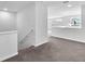 Upstairs landing area with neutral carpet, view of the living area, and lots of natural light at 3113 Marine Grass Dr, Wimauma, FL 33598