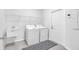 Functional laundry room featuring modern appliances, ample shelving, and a utility sink, making chores a breeze at 3113 Marine Grass Dr, Wimauma, FL 33598