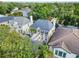 Aerial view of a beautiful home with dark roof, a second story porch, pool, and lush landscaping at 3117 W Knights Ave, Tampa, FL 33611