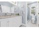 Bright bathroom with marble countertop, dual sinks, white cabinetry, and walk-in shower at 3117 W Knights Ave, Tampa, FL 33611