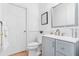 Bathroom featuring white walls, blue vanity, framed art and wooden floors at 3117 W Knights Ave, Tampa, FL 33611