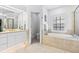 Bright bathroom featuring soaking tub, vanity, and walk-in shower, offering convenience and luxury at 3117 W Knights Ave, Tampa, FL 33611