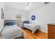 Bright bedroom with hardwood floors, ceiling fan, two twin beds, and natural light at 3117 W Knights Ave, Tampa, FL 33611