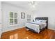 Bedroom with hardwood floors, two windows and a bed with blue and gray accents at 3117 W Knights Ave, Tampa, FL 33611