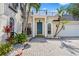 Two-story home with palm trees, an intricate balcony and a spacious brick driveway at 3117 W Knights Ave, Tampa, FL 33611