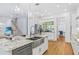 Open kitchen featuring a stainless steel dishwasher, white cabinets, and hardwood floors at 3117 W Knights Ave, Tampa, FL 33611