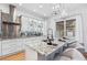 Bright kitchen featuring white cabinets, stainless steel backsplash and modern island with seating at 3117 W Knights Ave, Tampa, FL 33611