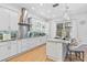 Bright kitchen featuring white cabinets, stainless steel backsplash and modern island with seating at 3117 W Knights Ave, Tampa, FL 33611