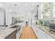 Open kitchen showcasing white cabinets, stainless steel appliances, and hardwood floors at 3117 W Knights Ave, Tampa, FL 33611