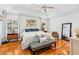 Cozy main bedroom with hardwood floors, ceiling fan, and accent wall, offering comfort and style at 3117 W Knights Ave, Tampa, FL 33611