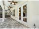Covered patio with stone flooring, ceiling fans, and double glass doors to indoors at 3117 W Knights Ave, Tampa, FL 33611