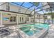 Backyard pool and attached hot tub with sun-bathing chairs, covered patio with ceiling fans and an outdoor TV at 3117 W Knights Ave, Tampa, FL 33611