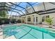 Backyard pool and attached hot tub, covered patio with ceiling fans and an outdoor TV, as well as sun-bathing chairs at 3117 W Knights Ave, Tampa, FL 33611