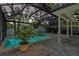 Screened-in pool area with outdoor seating and lush greenery offers a private retreat at 3117 W Knights Ave, Tampa, FL 33611