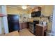 Functional kitchen featuring dark appliances, wood cabinets, and sufficient counter space for cooking at 342 N 40Th N St, St Petersburg, FL 33713