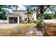 View of the home's backyard featuring lush tropical plants and a screened in porch at 3615 S Church Ave, Tampa, FL 33629