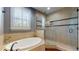 Bright bathroom featuring a standalone tub and a tiled glass shower at 3615 S Church Ave, Tampa, FL 33629